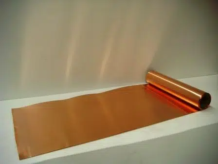 Copper shim stock partly unrolled on a workbench