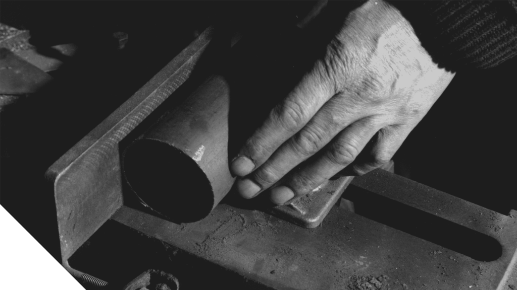 Hands handling precision shim stock on a workshop bench